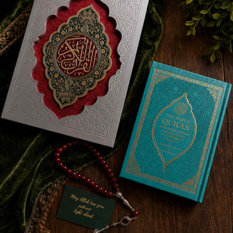 Premium Quran wedding set with decorative heirloom Quran box, beginner-friendly Noble Quran translation edition, and red tasbih beads arranged in a sophisticated beige and ivory wedding setting.